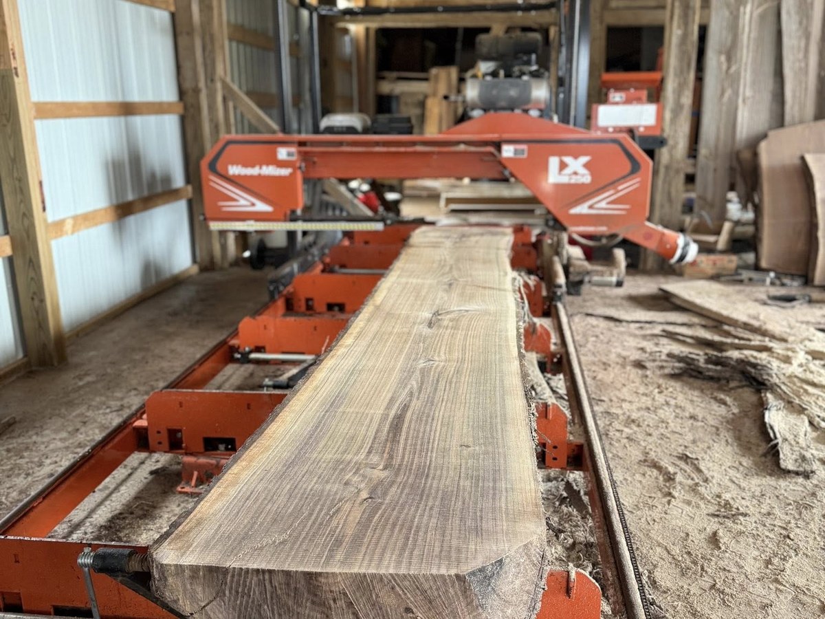 Wood-Mizer LX250 bandsaw mill with a freshly cut slab on the bed, inside the Vail Wood Products barn in Butler, Indiana