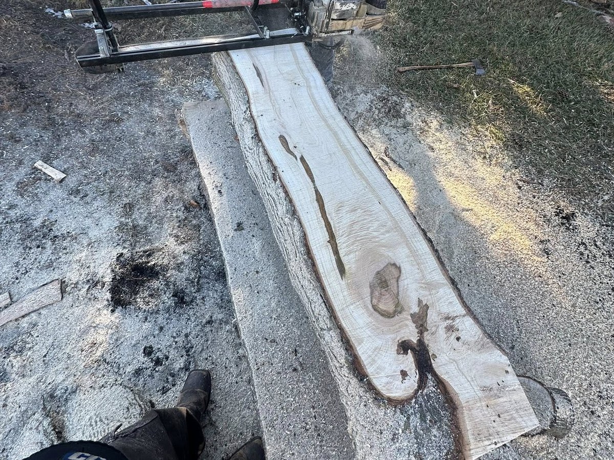 Alaskan chainsaw mill cutting a fresh live-edge slab on site — Vail Wood Products portable milling service