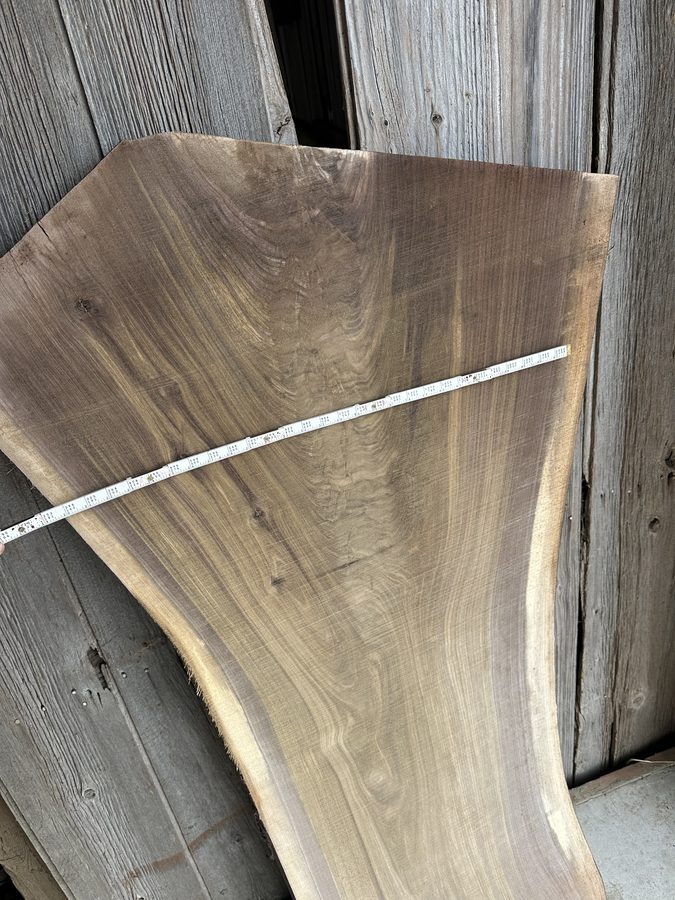 Close-up of wide live-edge slab with measuring tape showing width — cut on Wood-Mizer LX250